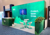 Big exhibition stand, single lightbox wall, L-shape counter and plant-topped plinth