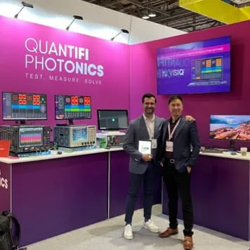Two happy Quantifi team members on their show stand looking at camera